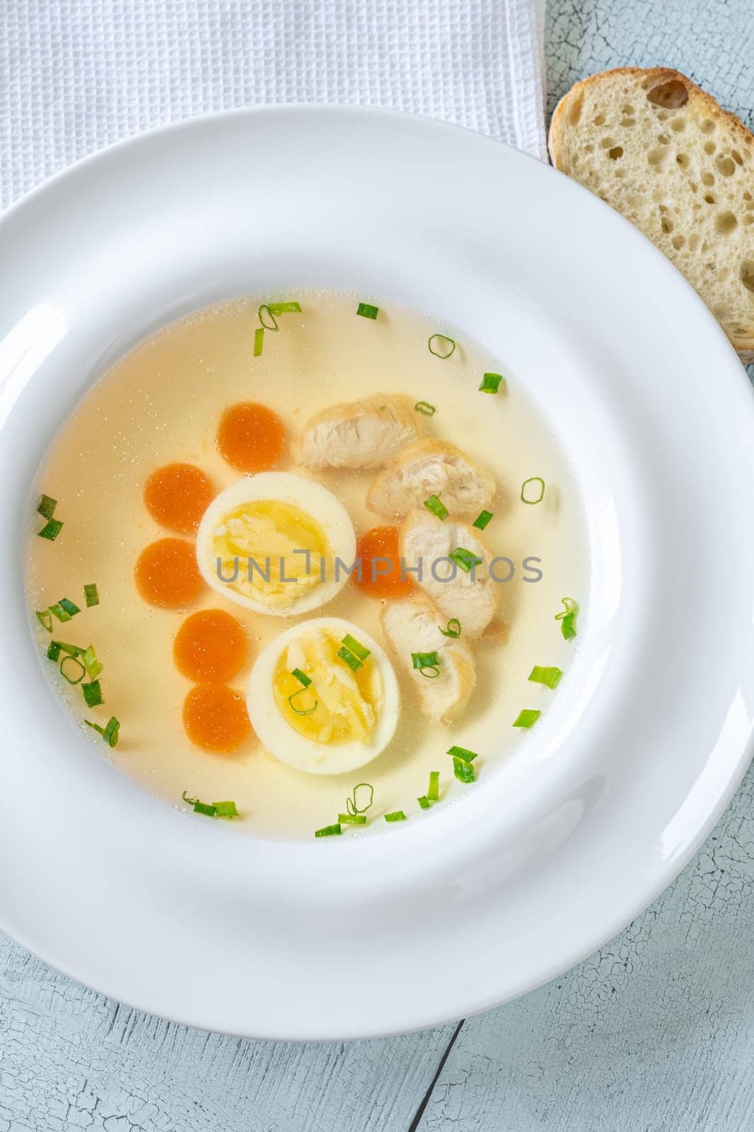 Portion of clear chicken broth in white plate