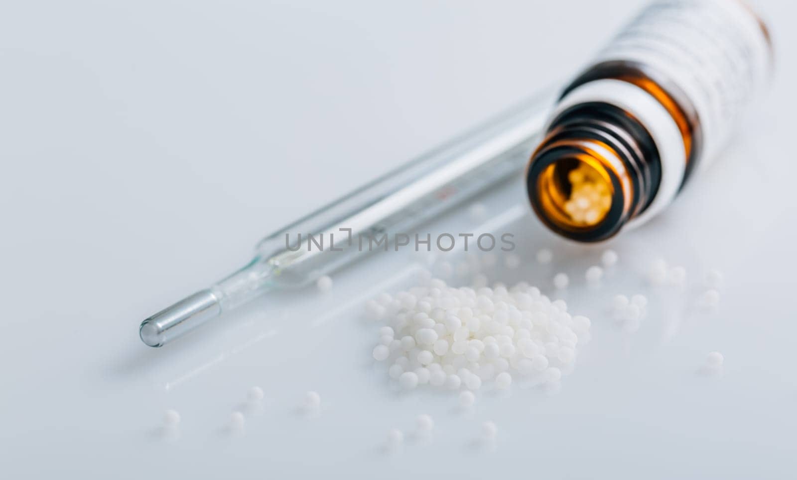 Homeopathic globules in small bottle, homeopathy concept