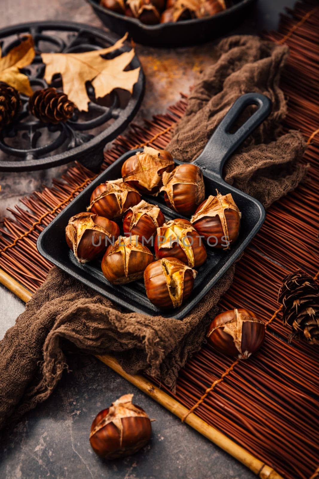 Roasted chestnuts in iron pan  on old kitchen table