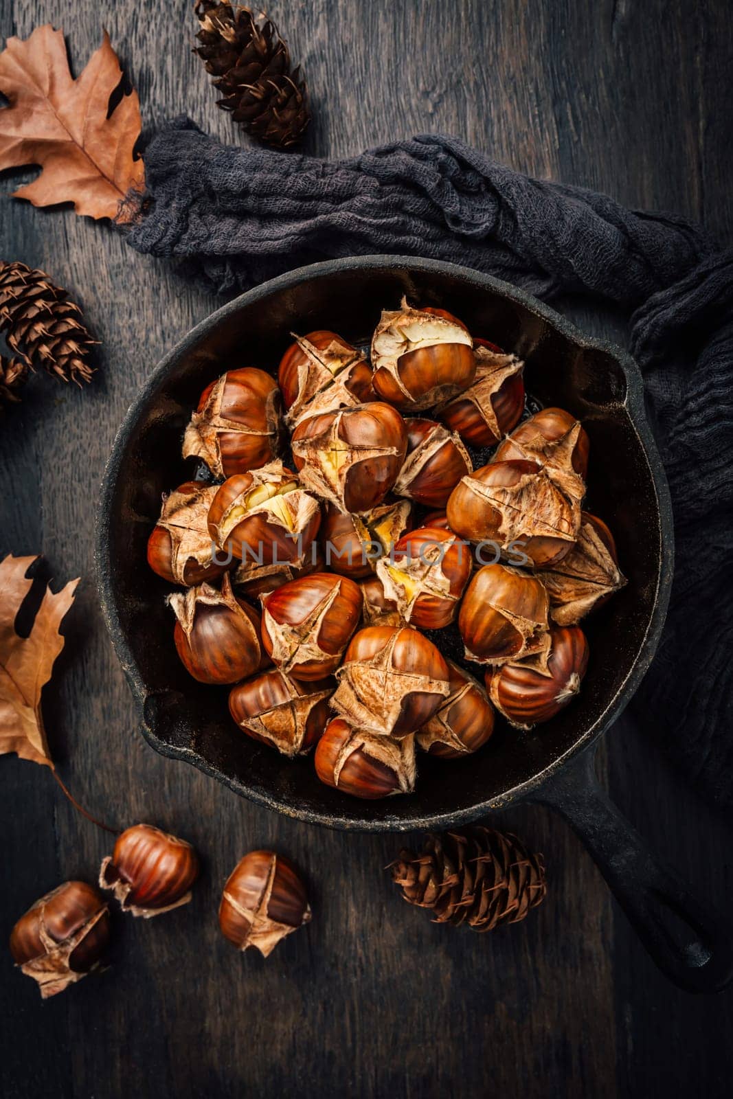 Roasted chestnuts in iron pan  on old kitchen table