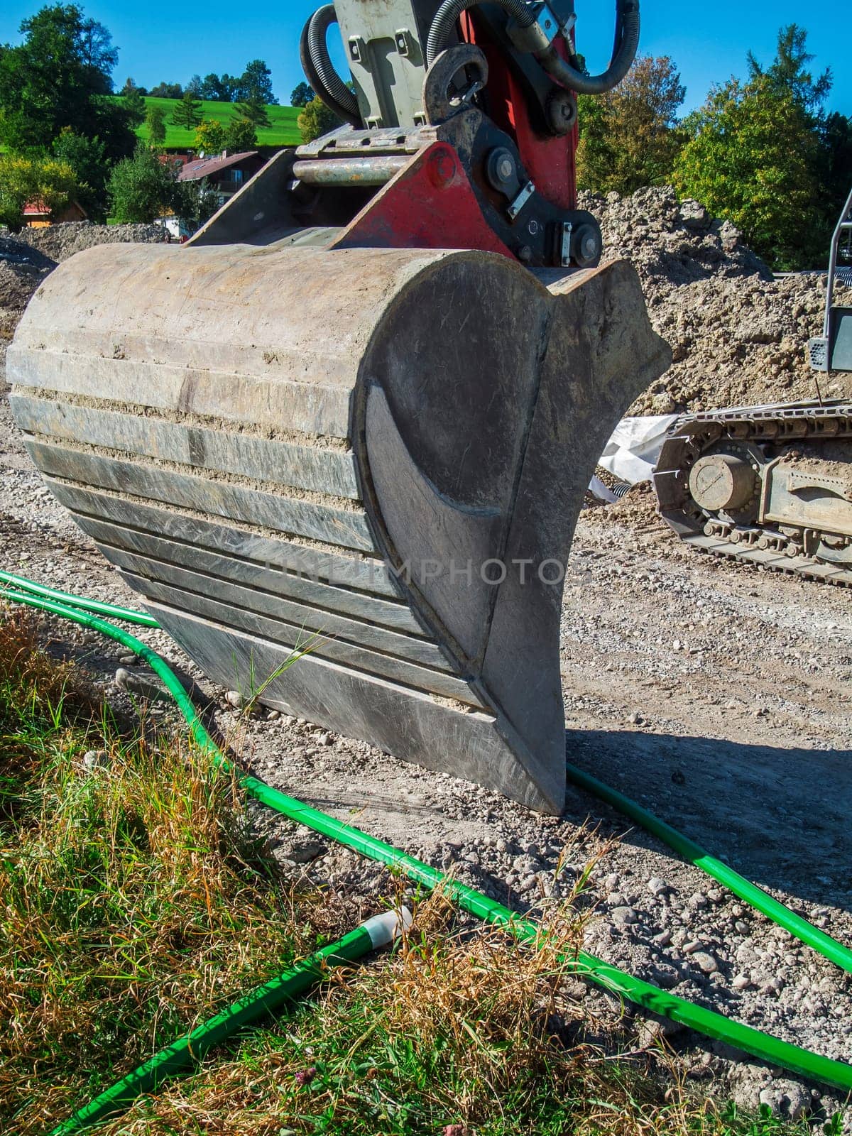 Wide angle close-up view of a lowered excavator bucket on a construction site in Bavaria.