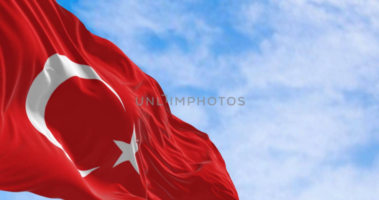 Close-up of Turkish national flag waving in the wind on a clear day. Red flag with white crescent and a star. 3D illustration render. Fluttering fabric. Selective focus