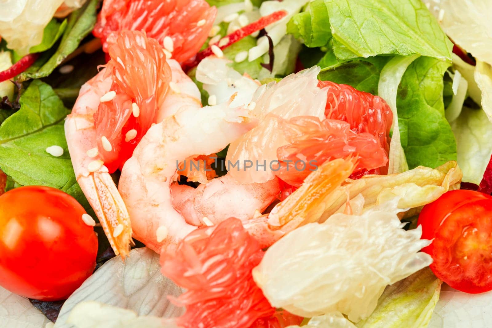 Diet salad with pomelo, shrimps and greens on a dark background. Healthy eating.