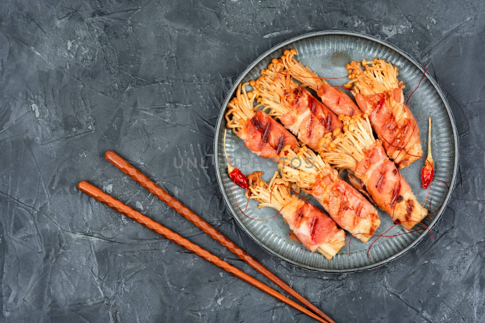 Enoki mushrooms appetizer fried in bacon. Bacon and enoki mushroom roll. Asian cuisine
