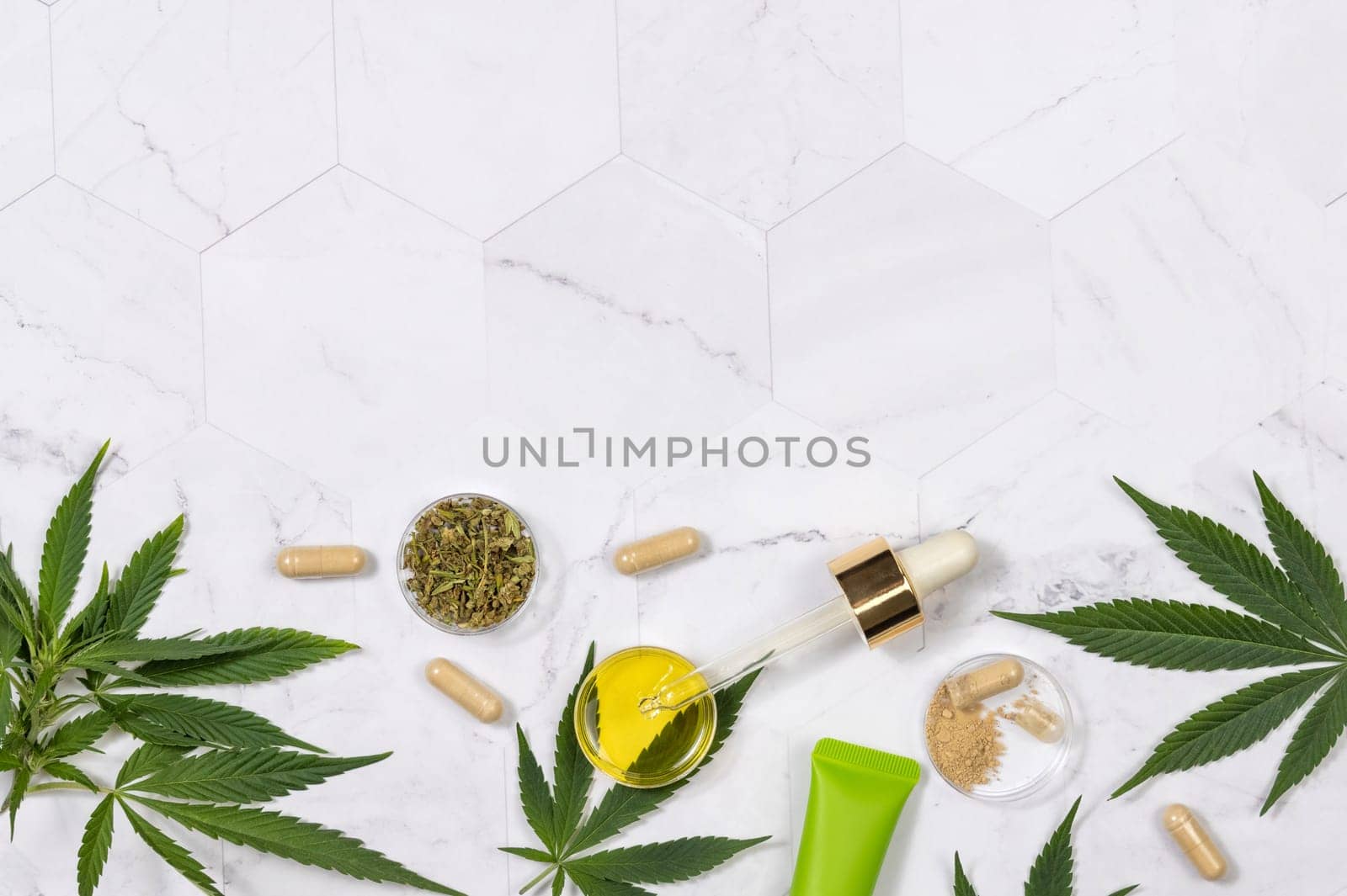Cosmetics, CBD oil, hemp powder capsules, dry tea and green cannabis sativa leaves on a marble table top view, Mockup, Copy space. Organic skincare beauty products.