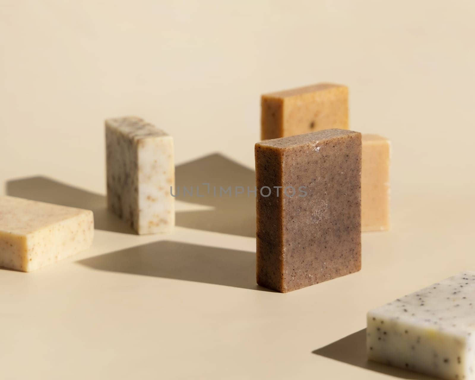 Natural herbal beige and brown soap bars on light beige close up, hard shadows. Hygiene products for Spa and skin care. Using organic handmade sopas in everyday routine