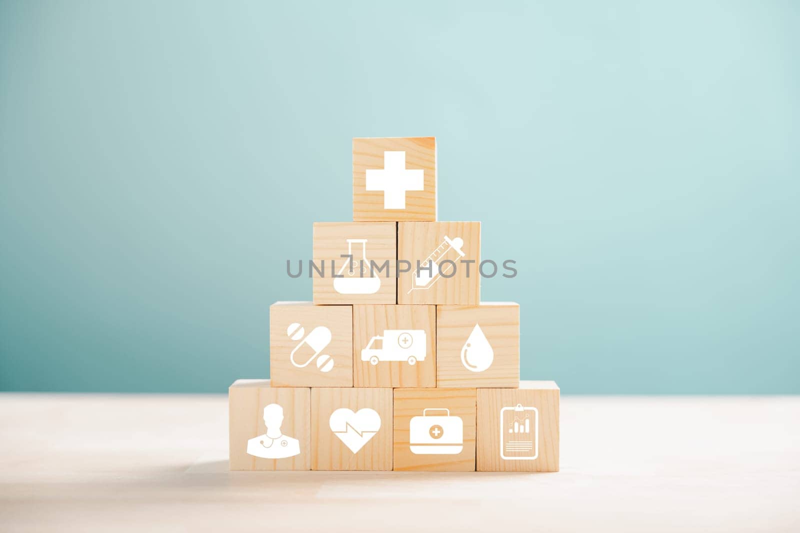 Metaphorical representation of healthcare and insurance with pyramid of wooden cubes. Medical insurance icon on white background, allowing copyspace for Health Insurance concept.