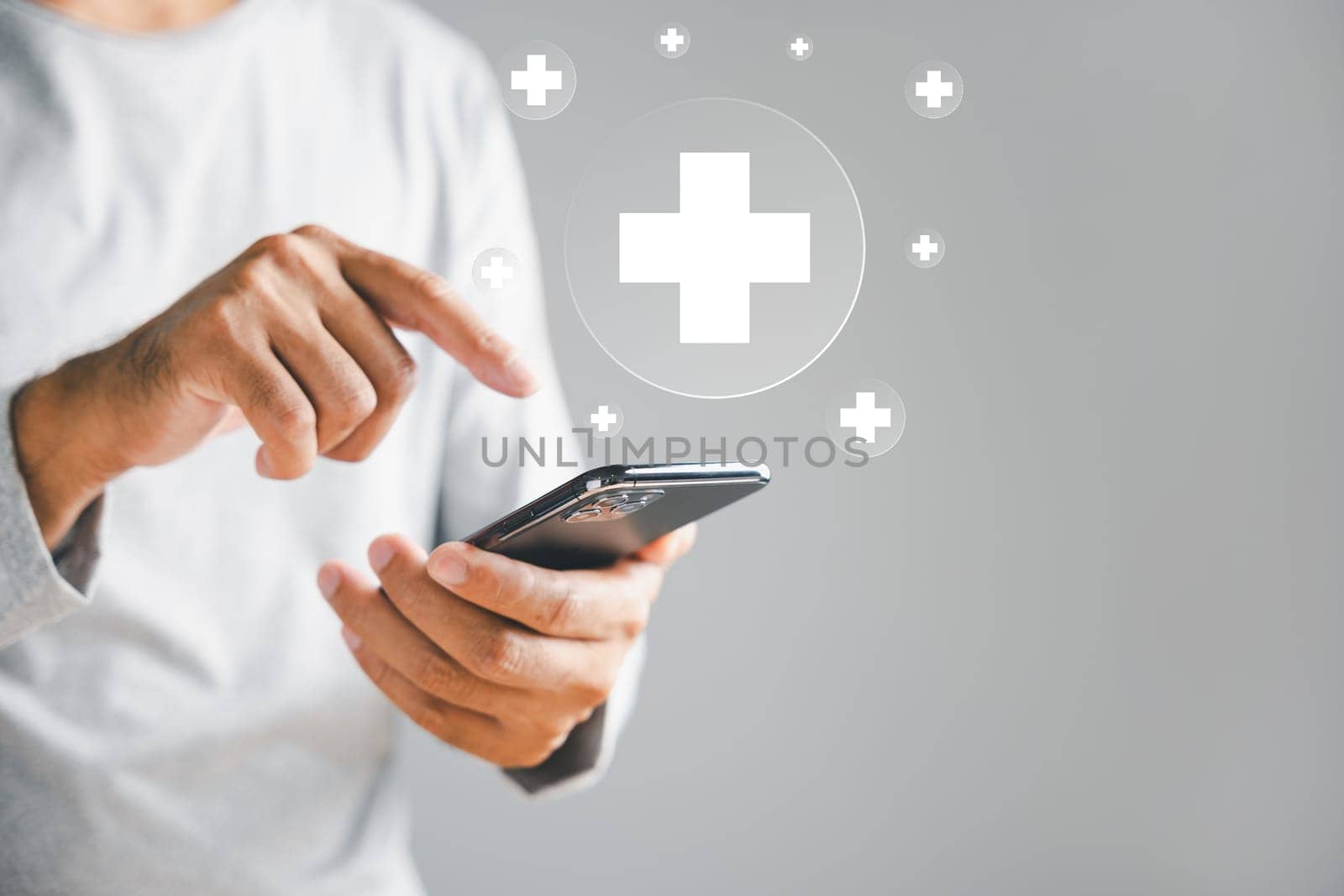 Mobile phone in man hand displays plus icon, symbolizing healthcare additions. Health insurance and medical benefits concept. Access to welfare health with background copy space.