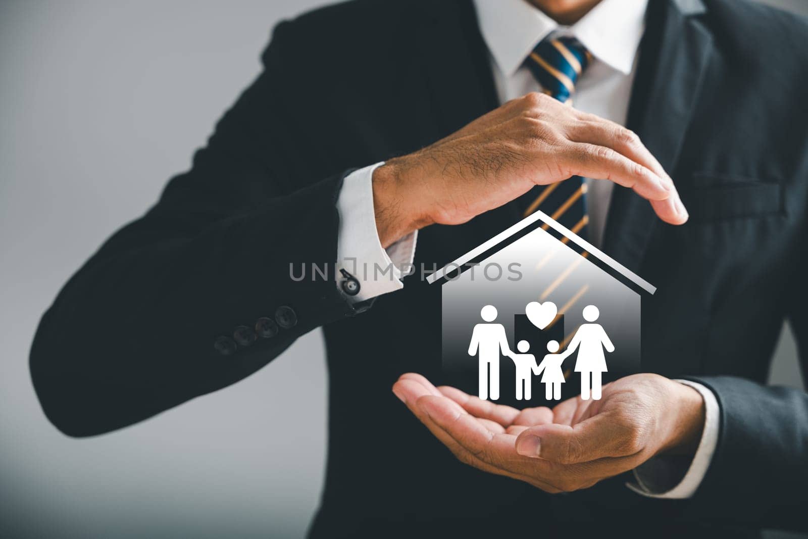 Businessman reassuring gesture highlights family safety, life, health, and house insurance icons. Insurance concept is vividly depicted, along with family life insurance and policy concepts.