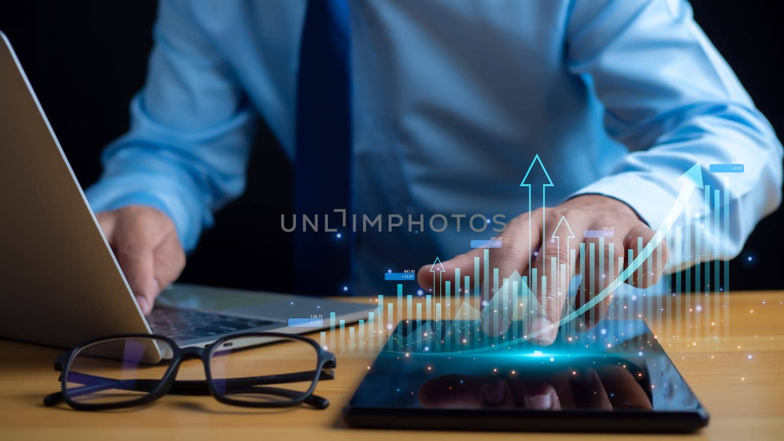 Businessman taps his finger on his tablet to display a graph with arrow for the future growth plan of his organization. finance, management, plan, management, strategy