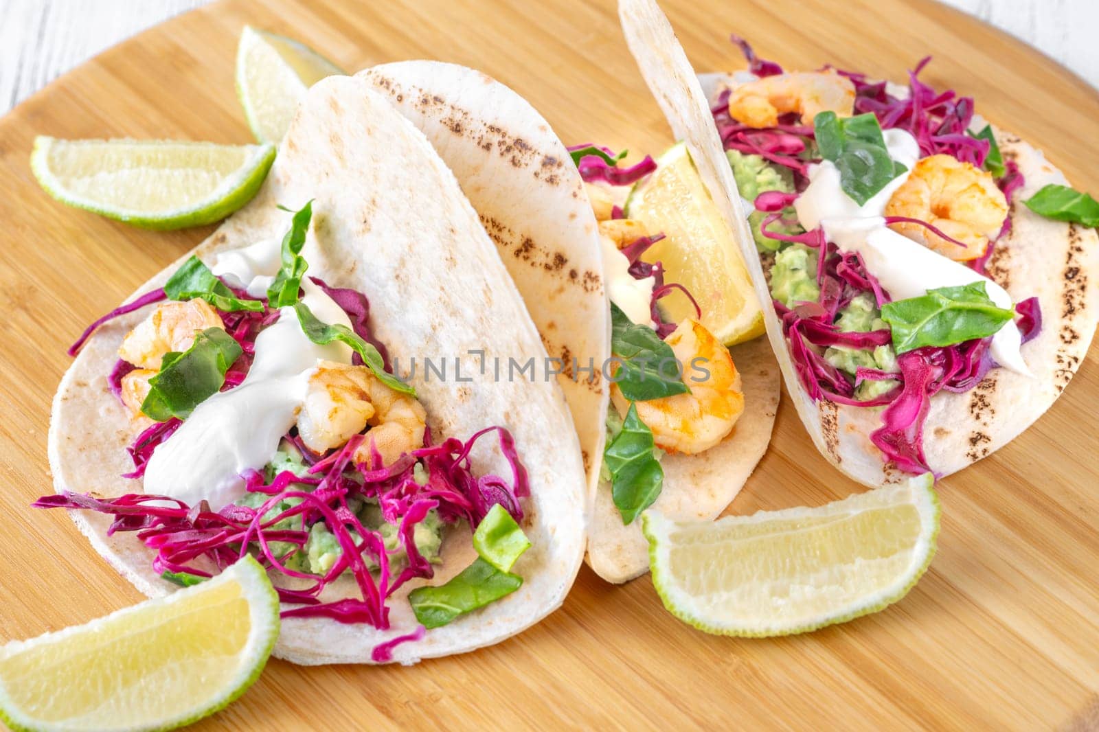 Tacos with shrimp, red cabbage, guacamole and sour cream