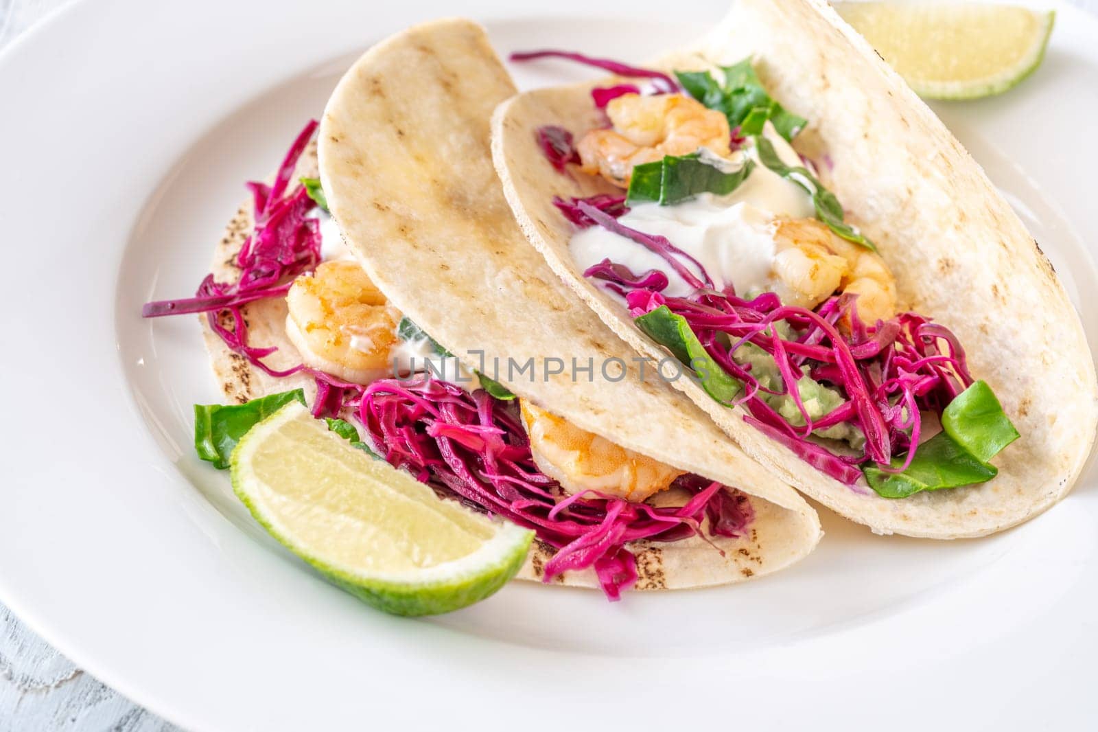 Tacos with shrimp, red cabbage, guacamole and sour cream