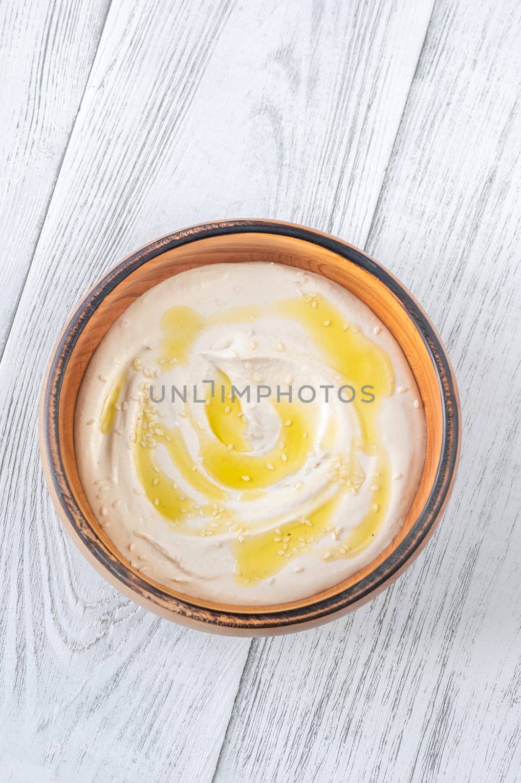 Wooden bowl of hummus on the white background