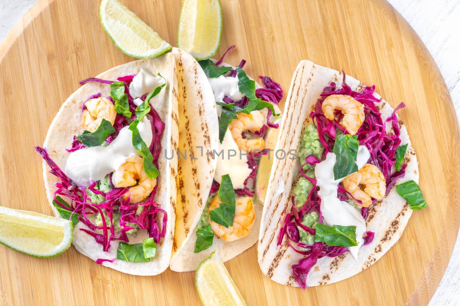 Tacos with shrimp, red cabbage, guacamole and sour cream