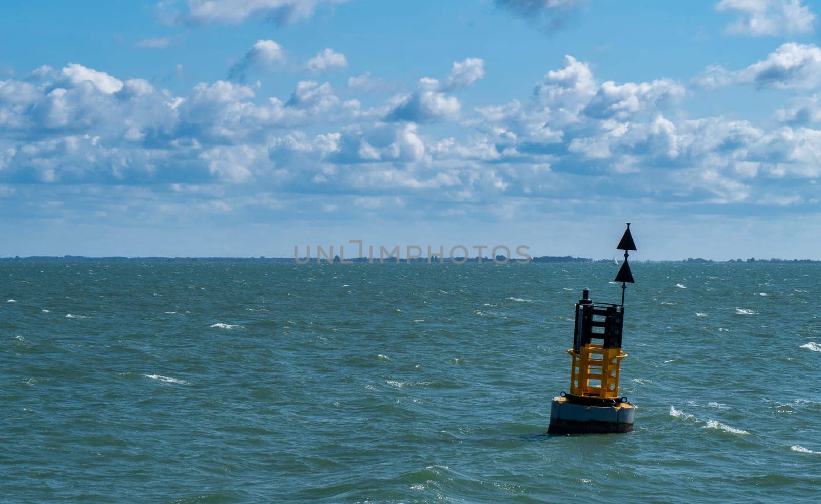 Yellow and black steel navigational floating buoy ,  a cardinal mark