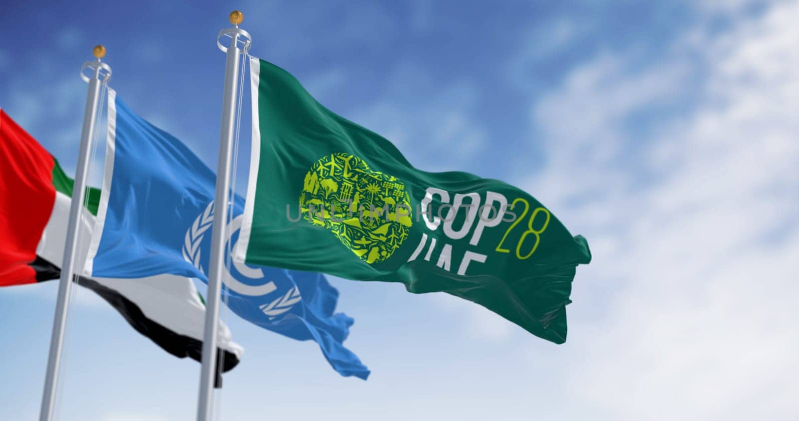 Dubai, UAE, Nov. 30 2023: Flags of COP28, UNFCCC and UAE waving on a clear day. 3d illustration render. Selective focus. Rippling fabric