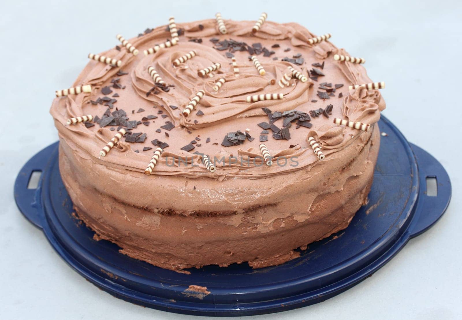 A round chocolate cake with embellishments and an inscription