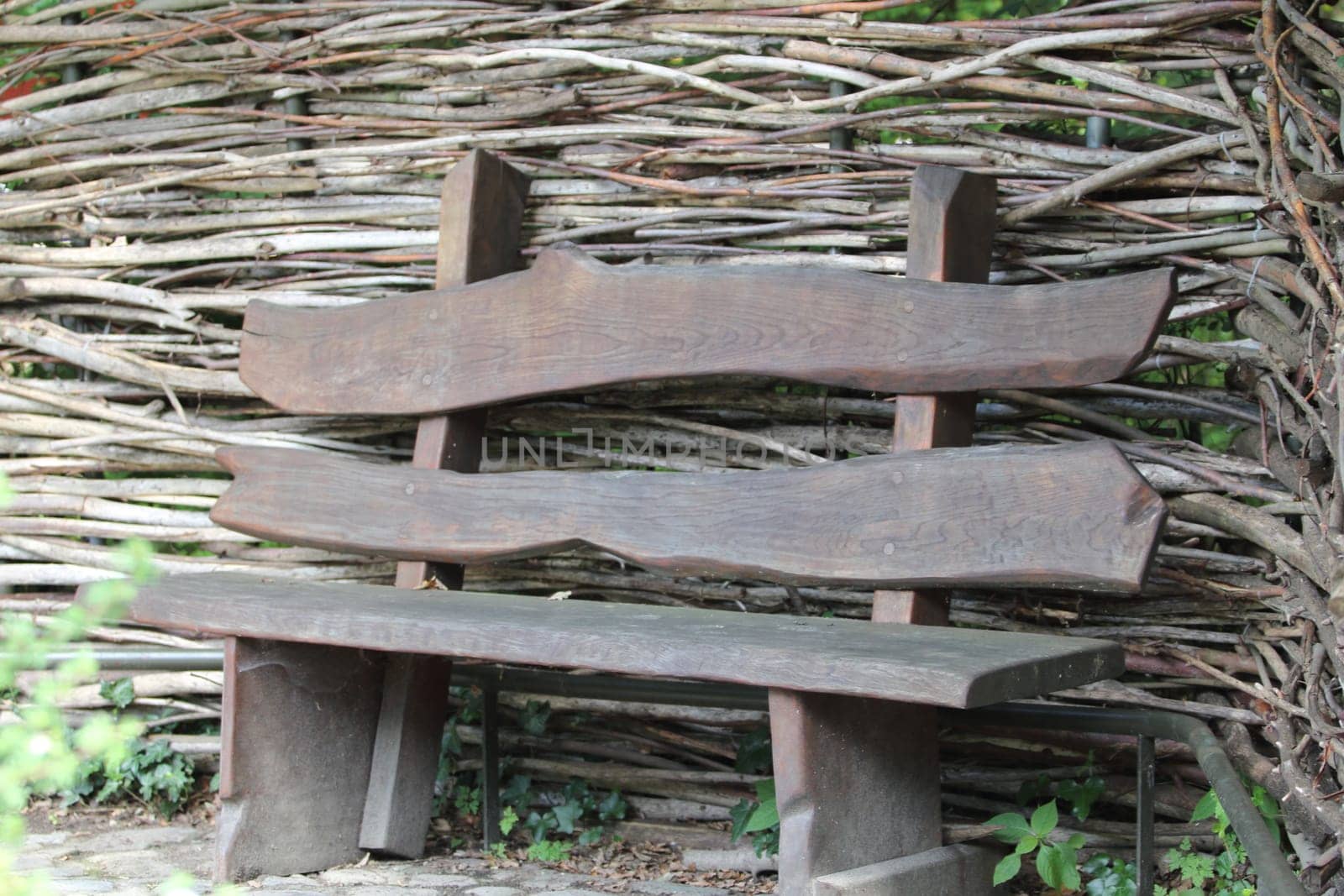 A wooden bench in front of  a timber wall