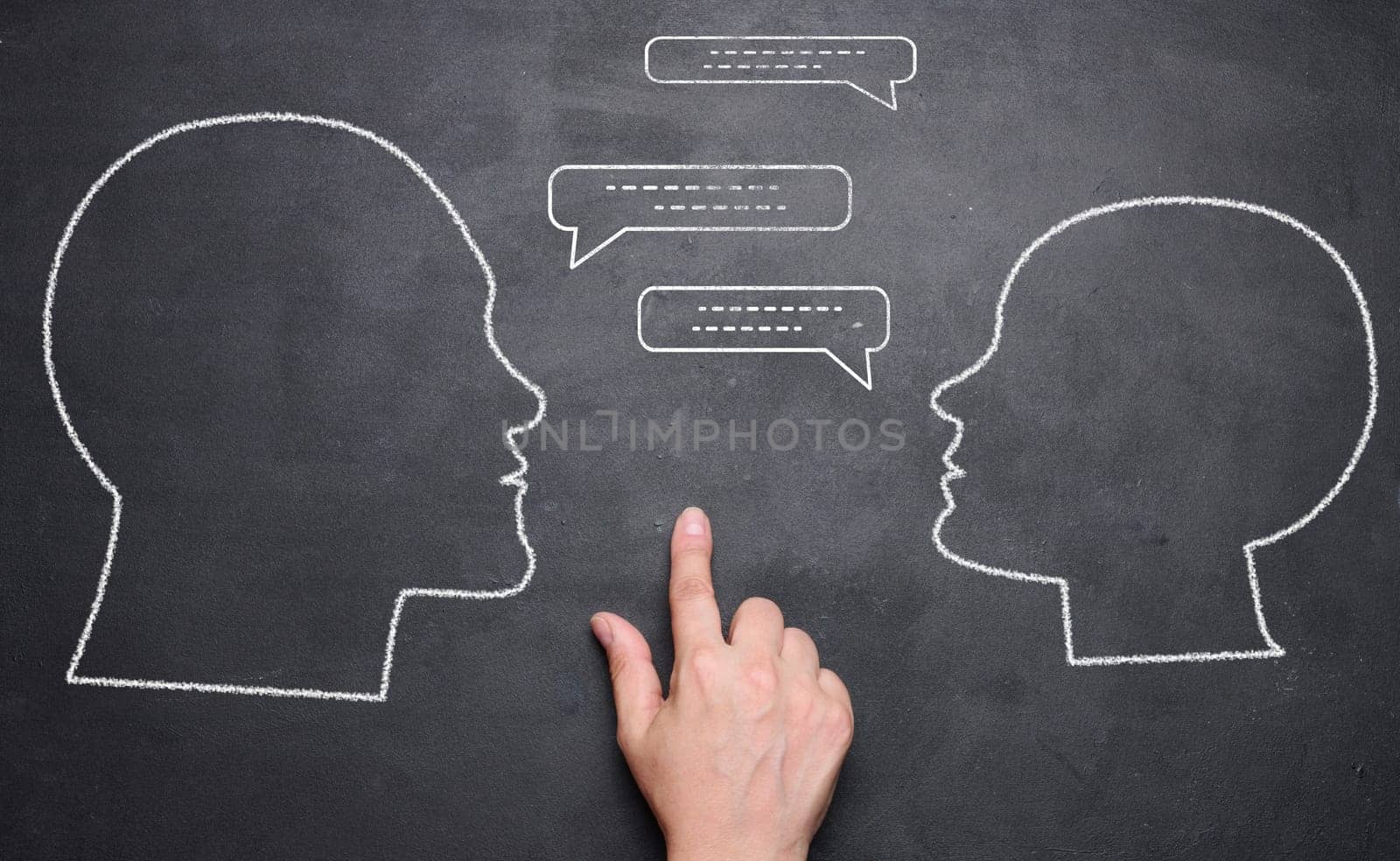 Chalk drawn silhouettes of a man and a woman, talking and a hand between them. Concept of discussion, reconciliation and quarrel