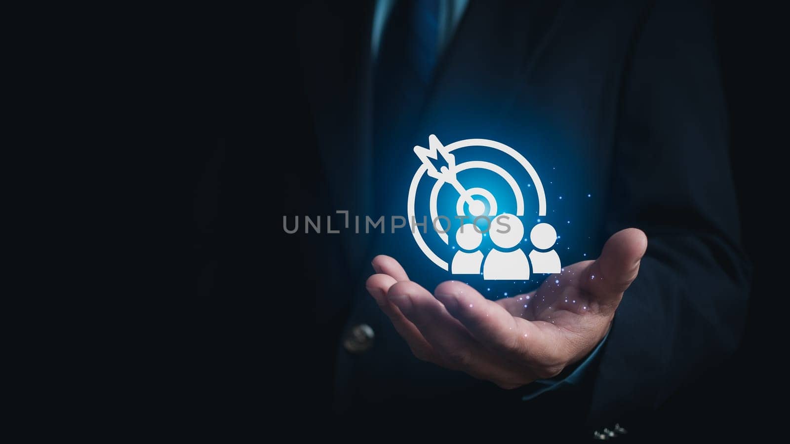 Human hand holding customer icons on dark background. Represents the selection of business goals, target customers, marketing plans and strategies, and customer-centric strategies.