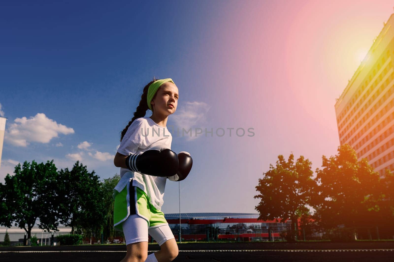 Female child boxer in gloves, feminism concept. Back to school, physical training.