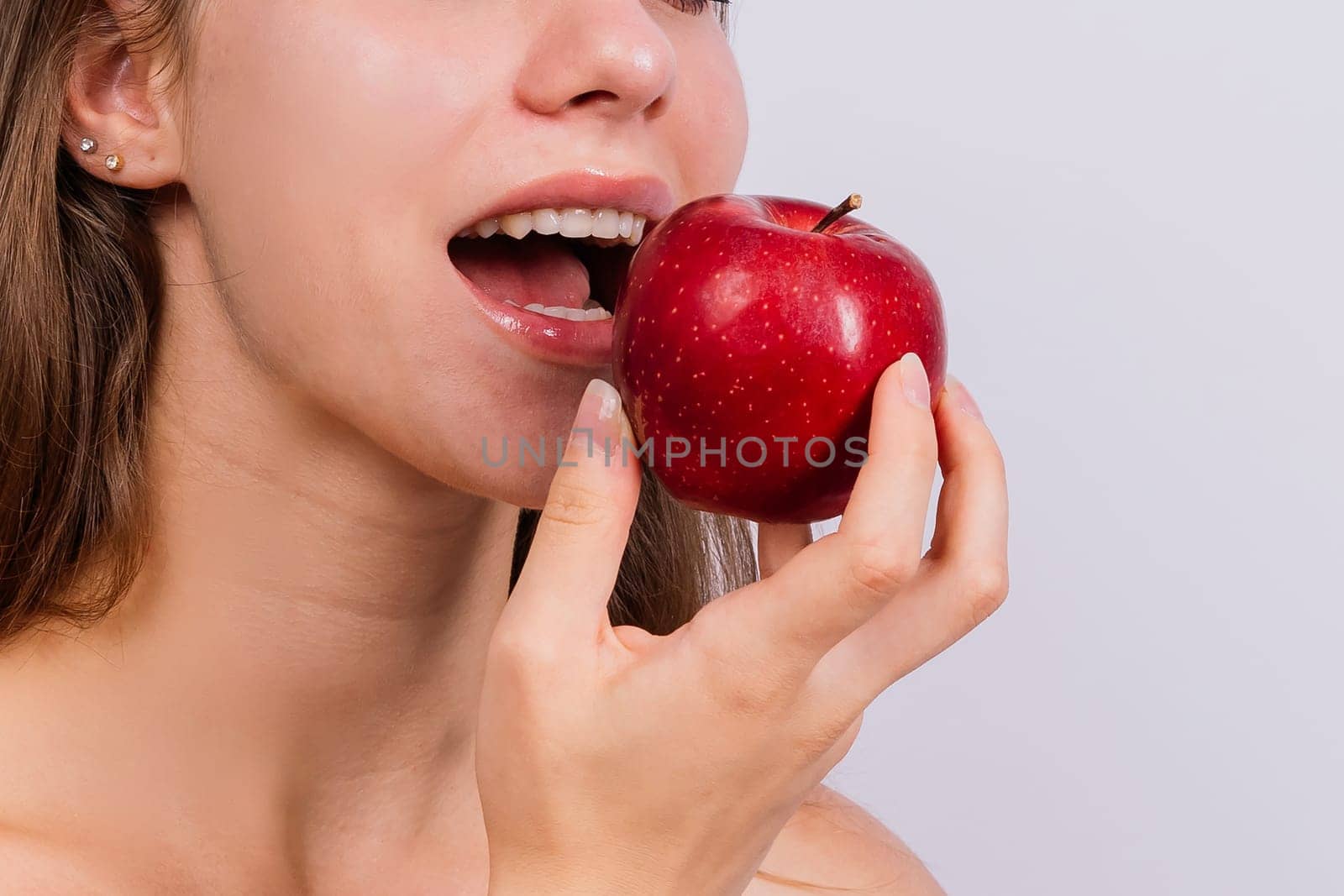 Cropped of sporty female with well fit body holding an apple, healthy food and fit body concept