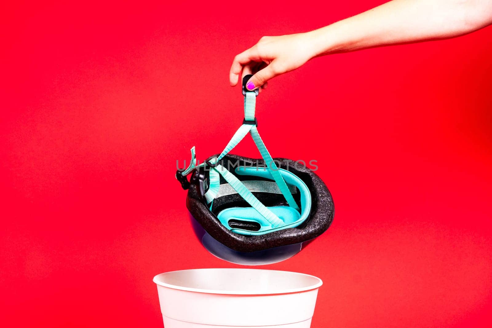 Photo of bike and engineer helmet in plastic trash bin, studio shot