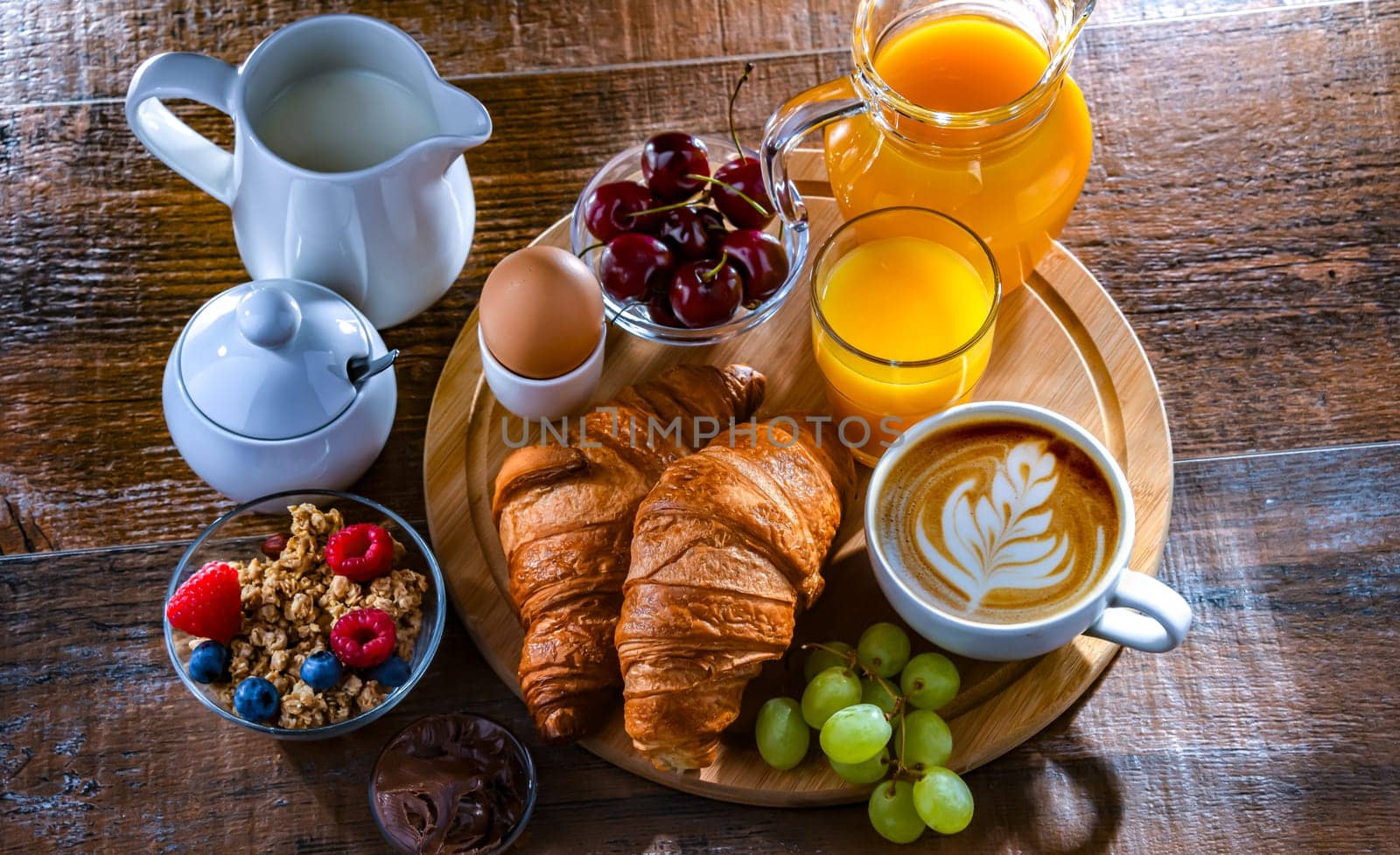 Breakfast served with coffee, orange juice, egg, cereals and croissants.