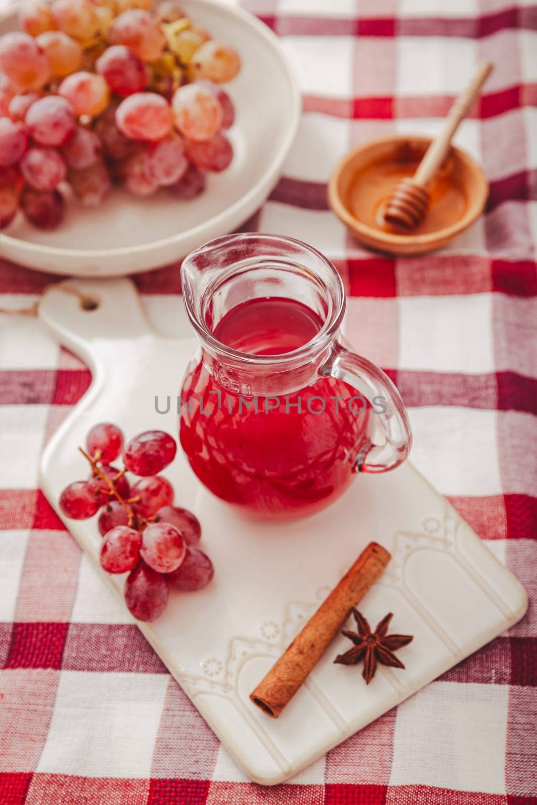 Homemade organic red vinegar with cinnamon and anise. Red grape balsamic vinegar made from fermented fresh grapes.