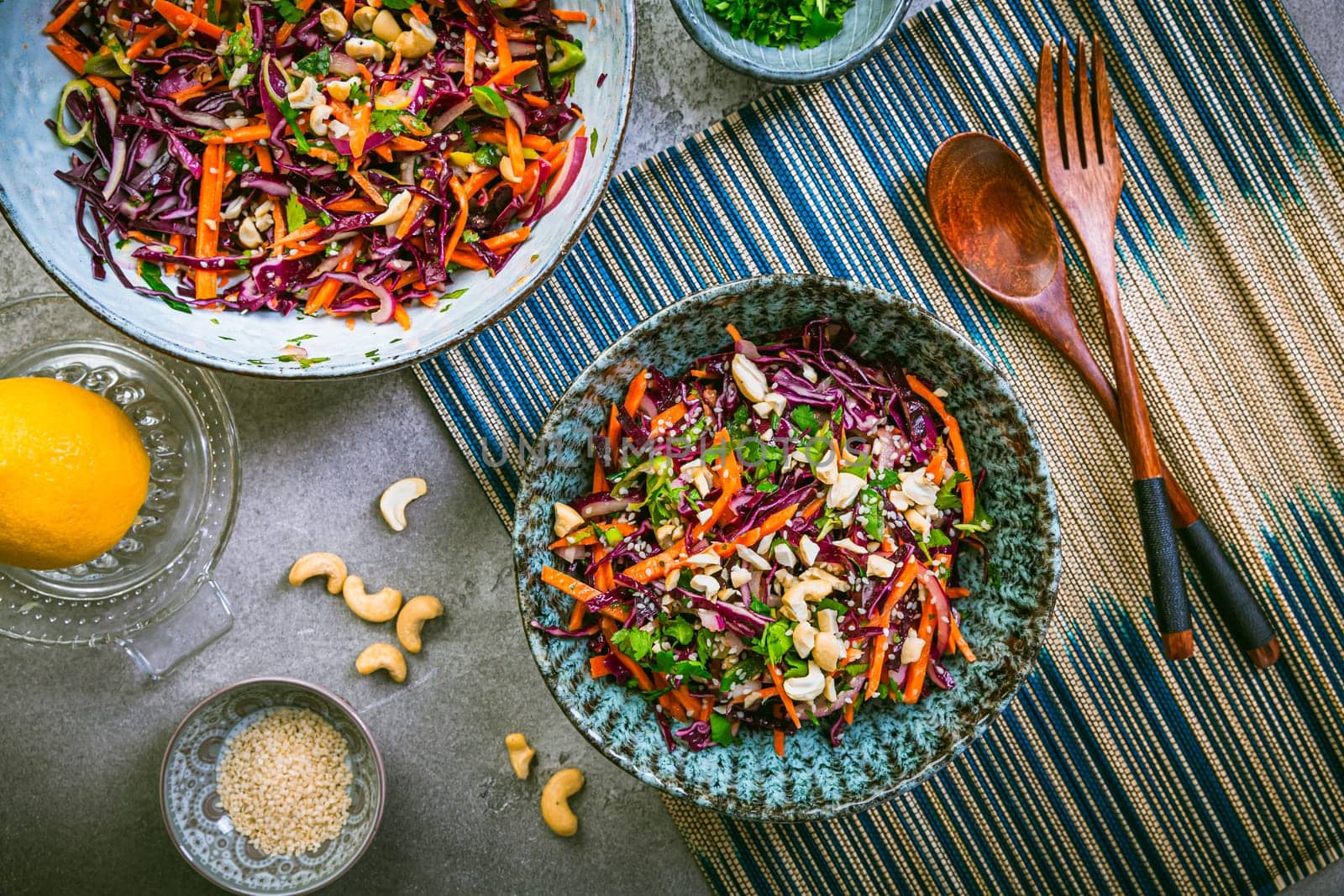 Red cabbage salad in Asian style with carrots, cilantro, cashew nuts and onions