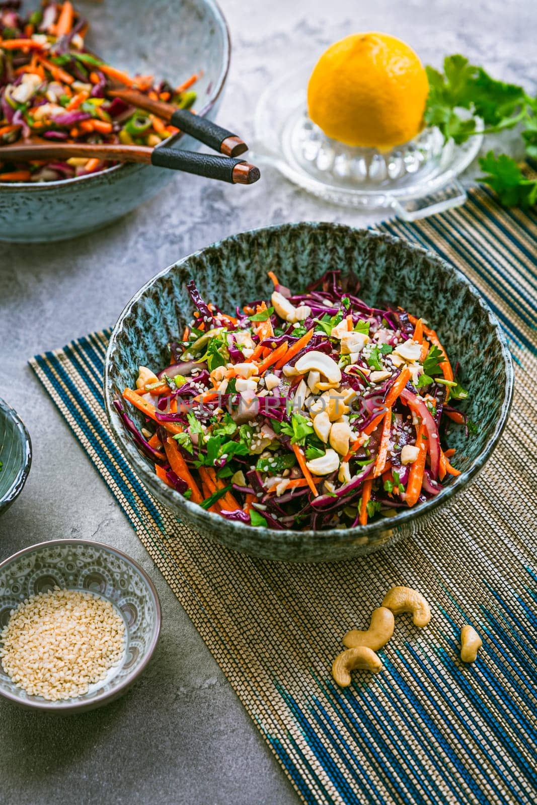 Red cabbage salad in Asian style with carrots, cilantro, cashew nuts and onions