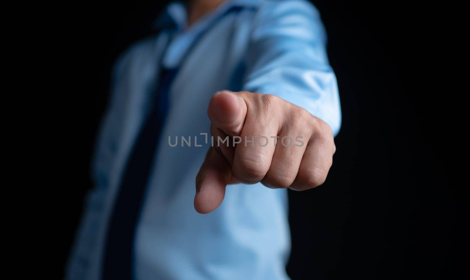 Employee makes a forward pointing gesture on a dark background.