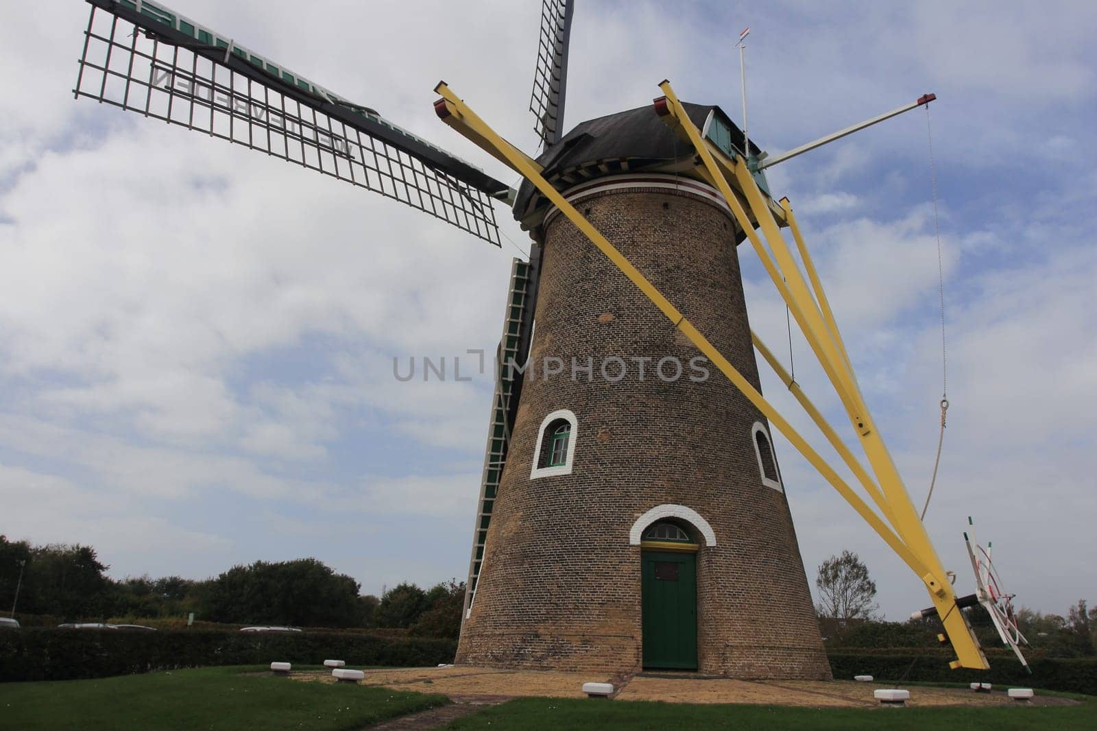A historic windmill with clouds and blue sky in the background