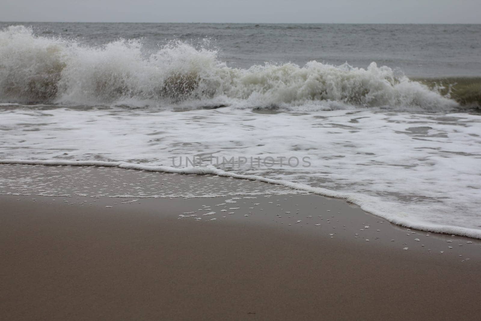 Waves with white crests inundate the sandy beach