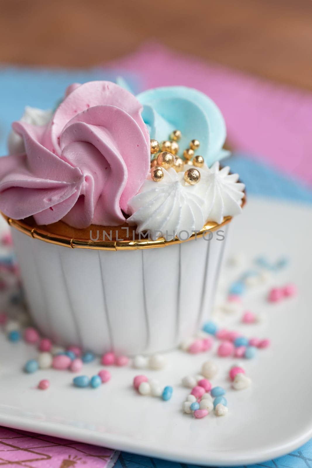 Cupcake blue and pink for gender party. boy or girl. delicious cupcakes with blue and pink cream, golden sparkles celebration concept when the gender of the child becomes known. Festive baby shower sweets concept close up