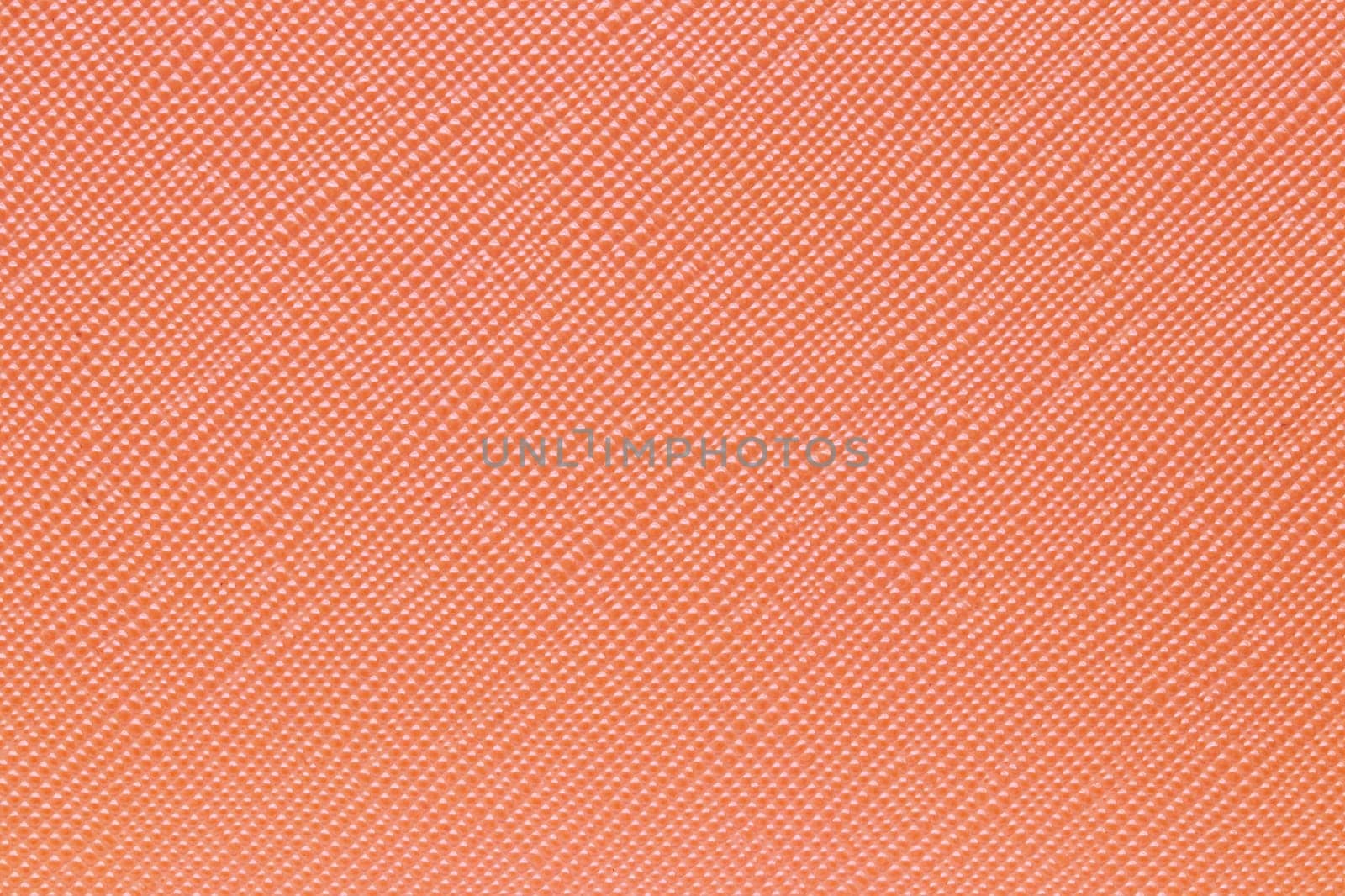 Seamless plastic texture background. Close-up of a detail from a orange surface of a cosmetic bag. Beautiful backdrop. Macro.