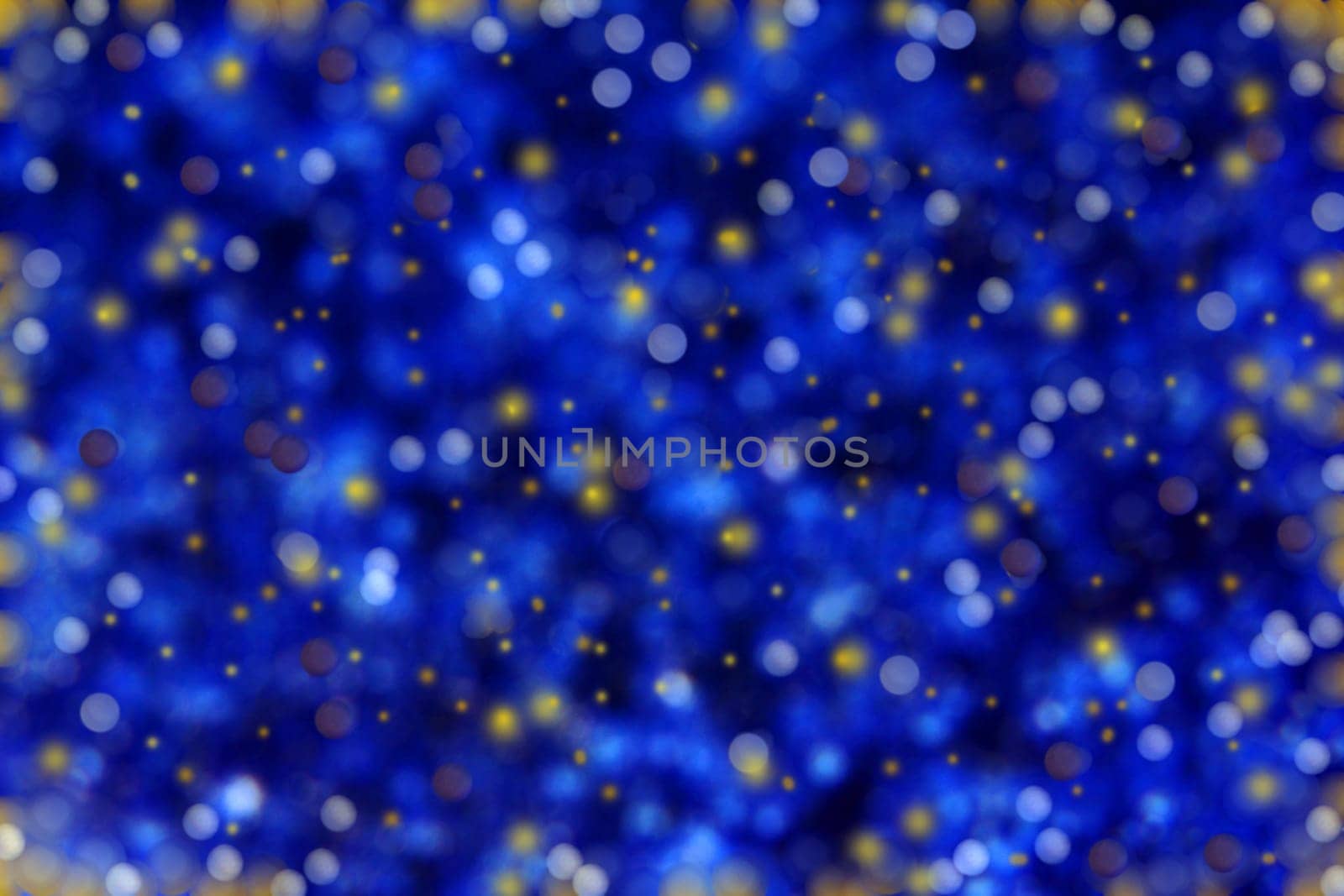 Blue blurred background with glittering snowflakes and dots