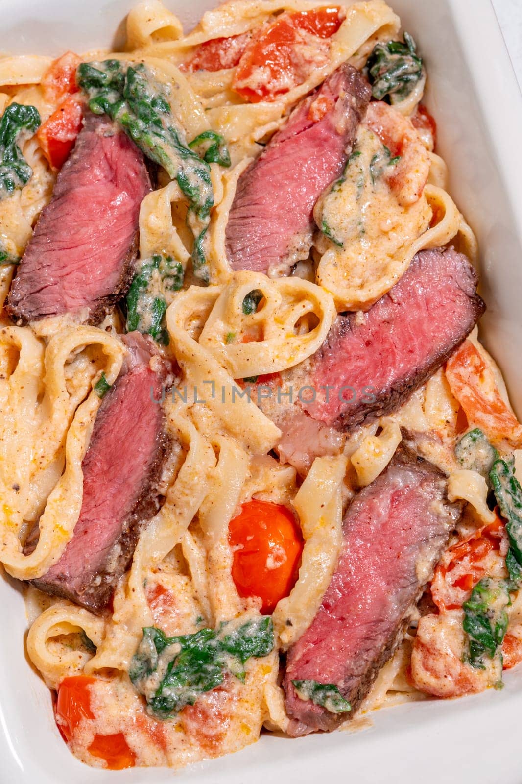 Creamy steak fettuccine pasta with spinach and tomatoes