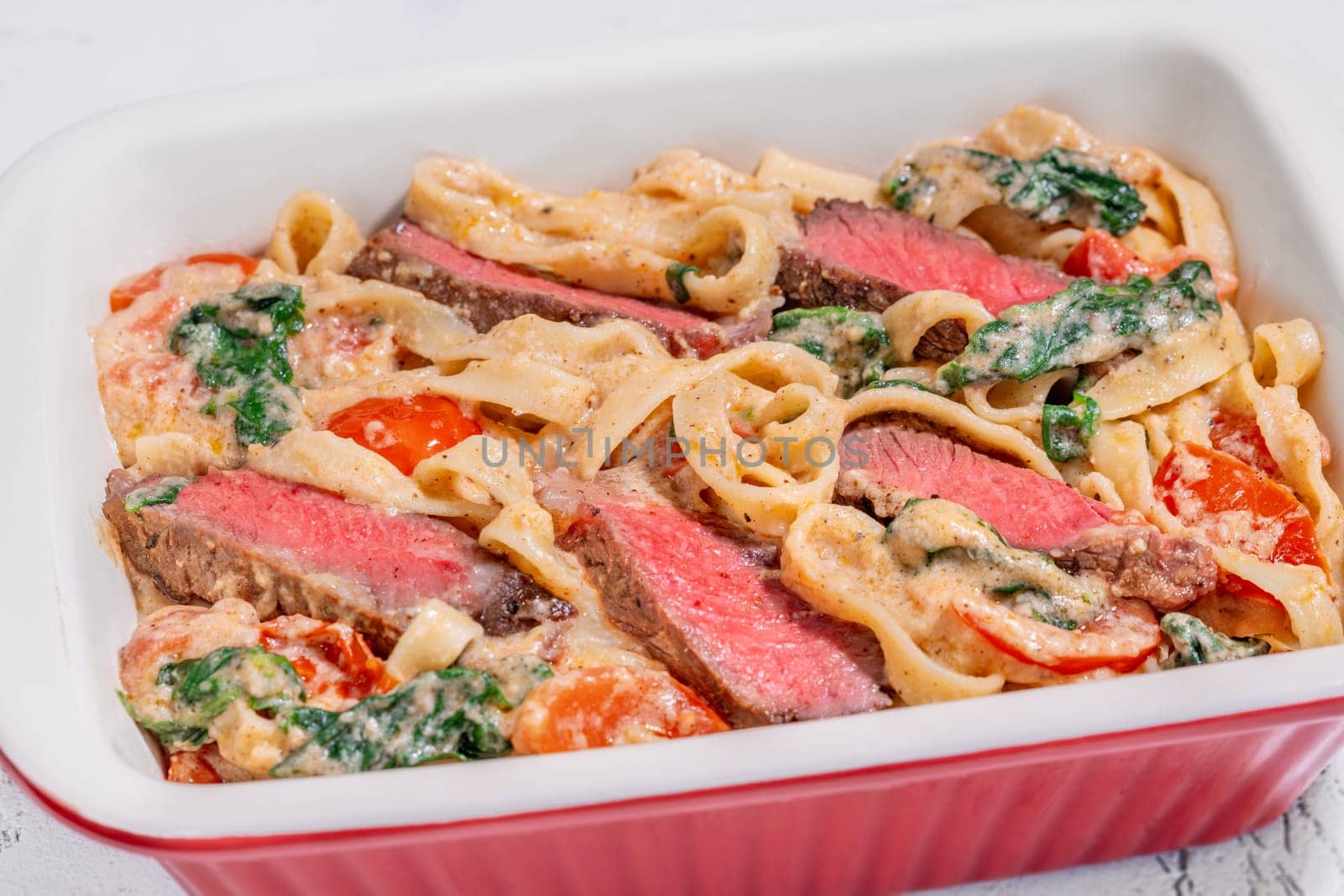 Creamy steak fettuccine pasta with spinach and tomatoes