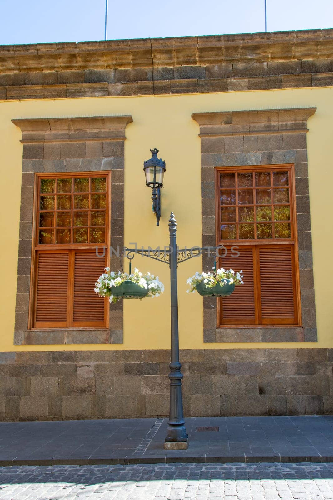 Old windows and flowers on a house on the Canary Island of Gran Canaria in Spain