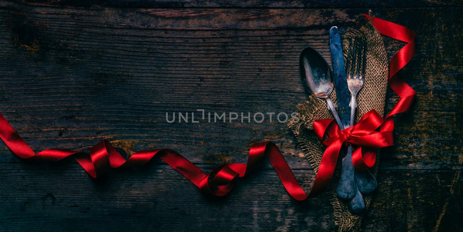Valentines dinner background with vintage silverware and red ribbon on wooden table. Luxury restaurant menu for romantic celebration event. Valentine day dine. Top view.