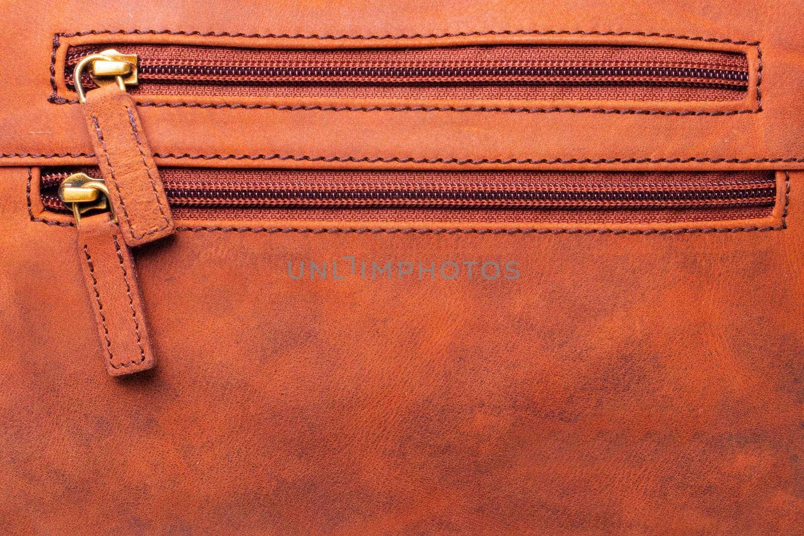 Zip fastener background texture. A high-resolution closeup of a detail from two closed plastic zip fastening on brown leather handbag. Macro photo.