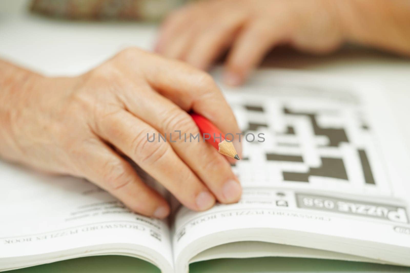 Bangkok, Thailand - May 15, 2022 elderly woman playing sudoku puzzle game for treatment dementia prevention and Alzheimer disease.