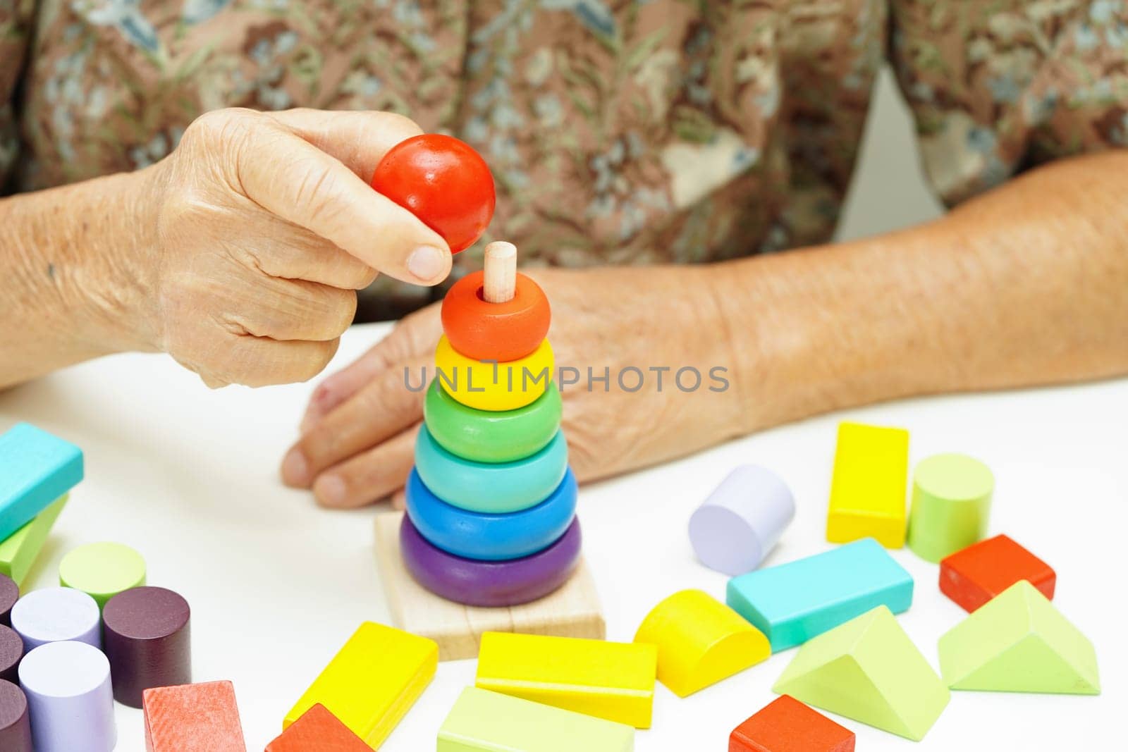Asian elderly woman playing puzzles game for treatment dementia prevention and Alzheimer disease.