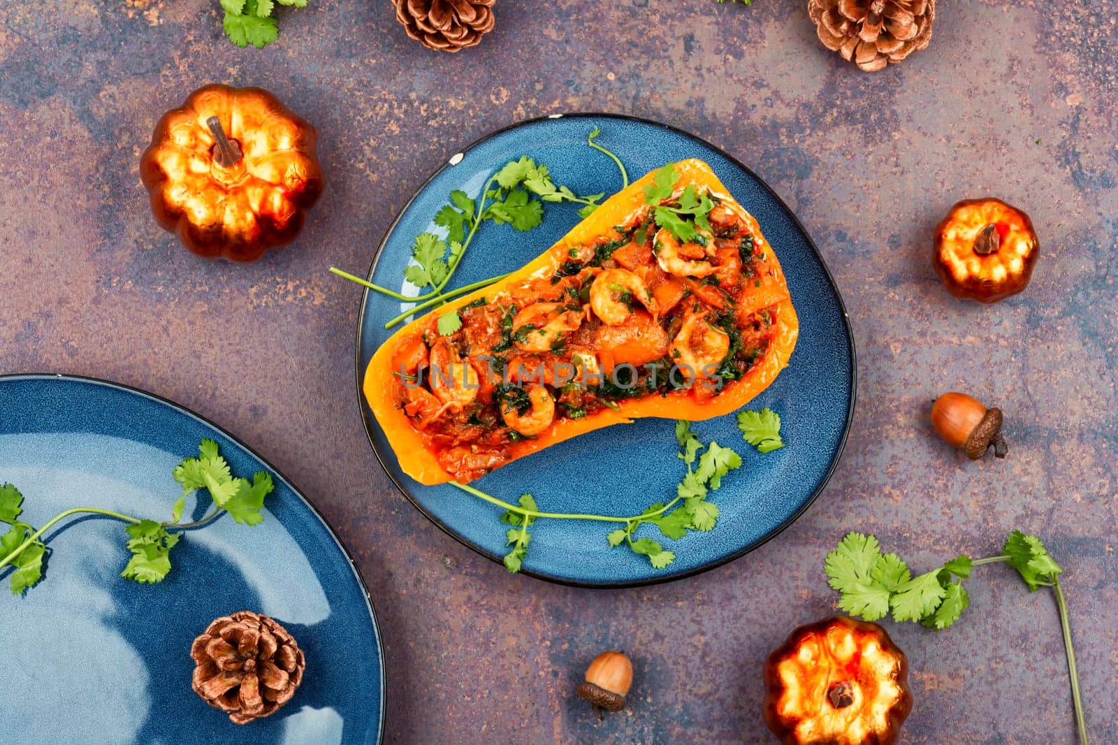 Half a butternut pumpkin stuffed with vegetables and shrimp. Flat lay. Copy space.
