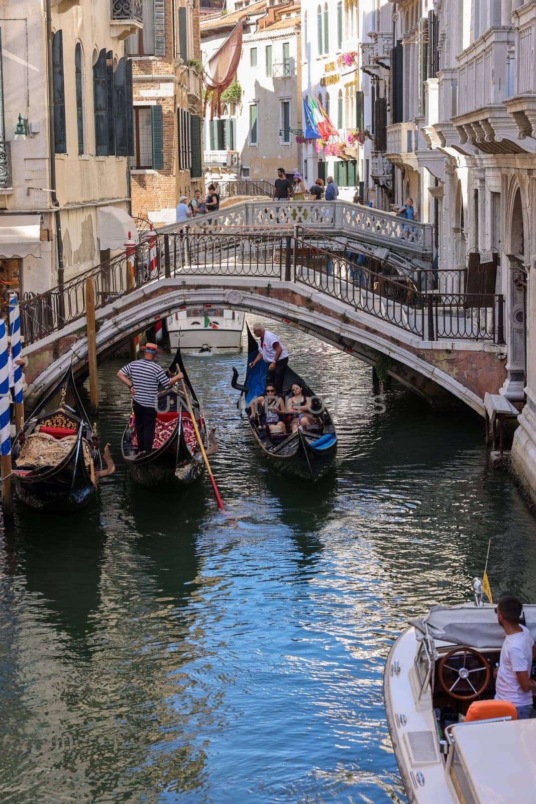 Venice, Italy - September 5, 2022: One of the most recognizable tourist attractions in the world - a gondola cruise through the narrow canals in Venice