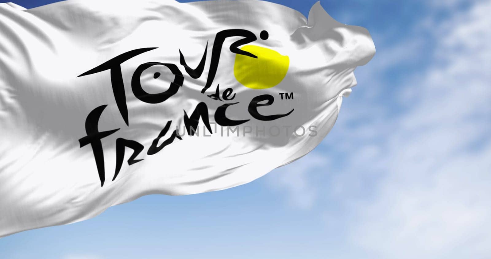 Paris, FR, Dec 2 2023: Tour de France flag waving on a clear day. Most important international cycling event of the year. Illustrative editorial 3d illustration render