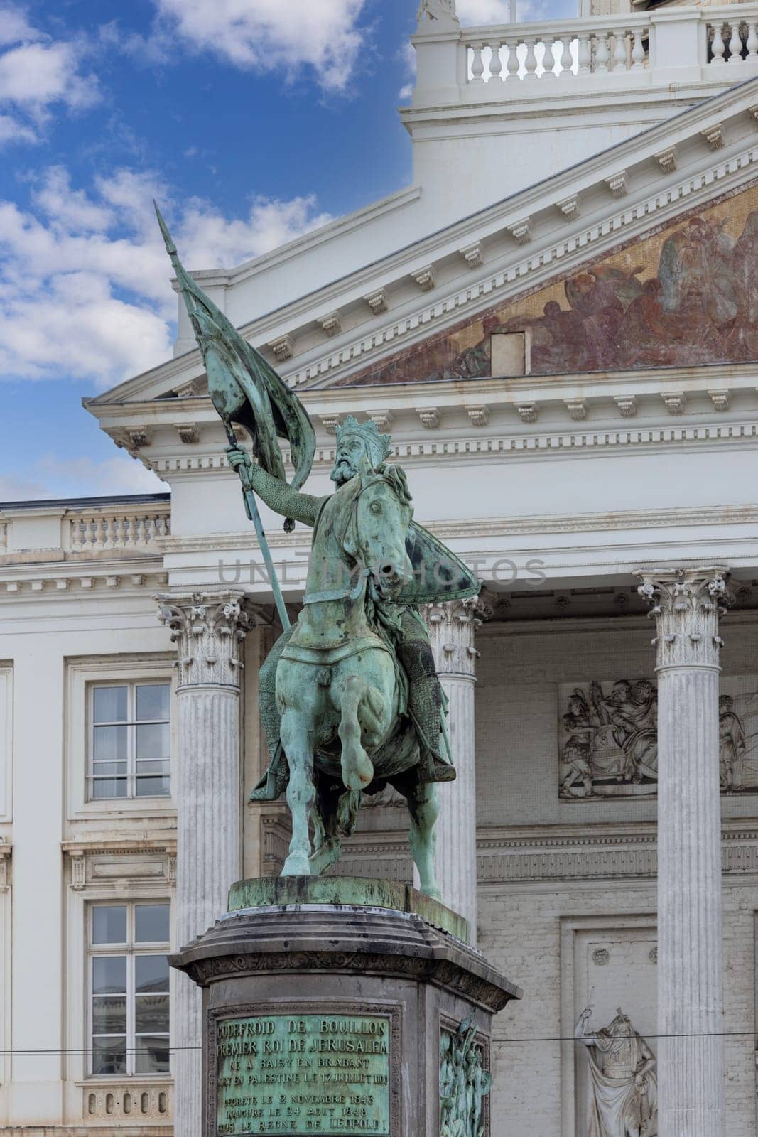 Brussels, Belgium - May 18, 2023: Statue of Godfrey of Bouillon at The Place Royale known as Koningsplein. Neoclassical Church of St. James on Coudenberg in a distance