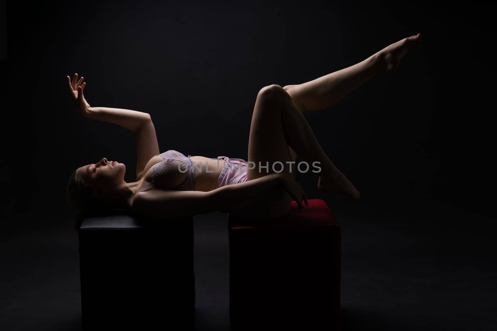 Low key portrait of beautiful female body on a dark background