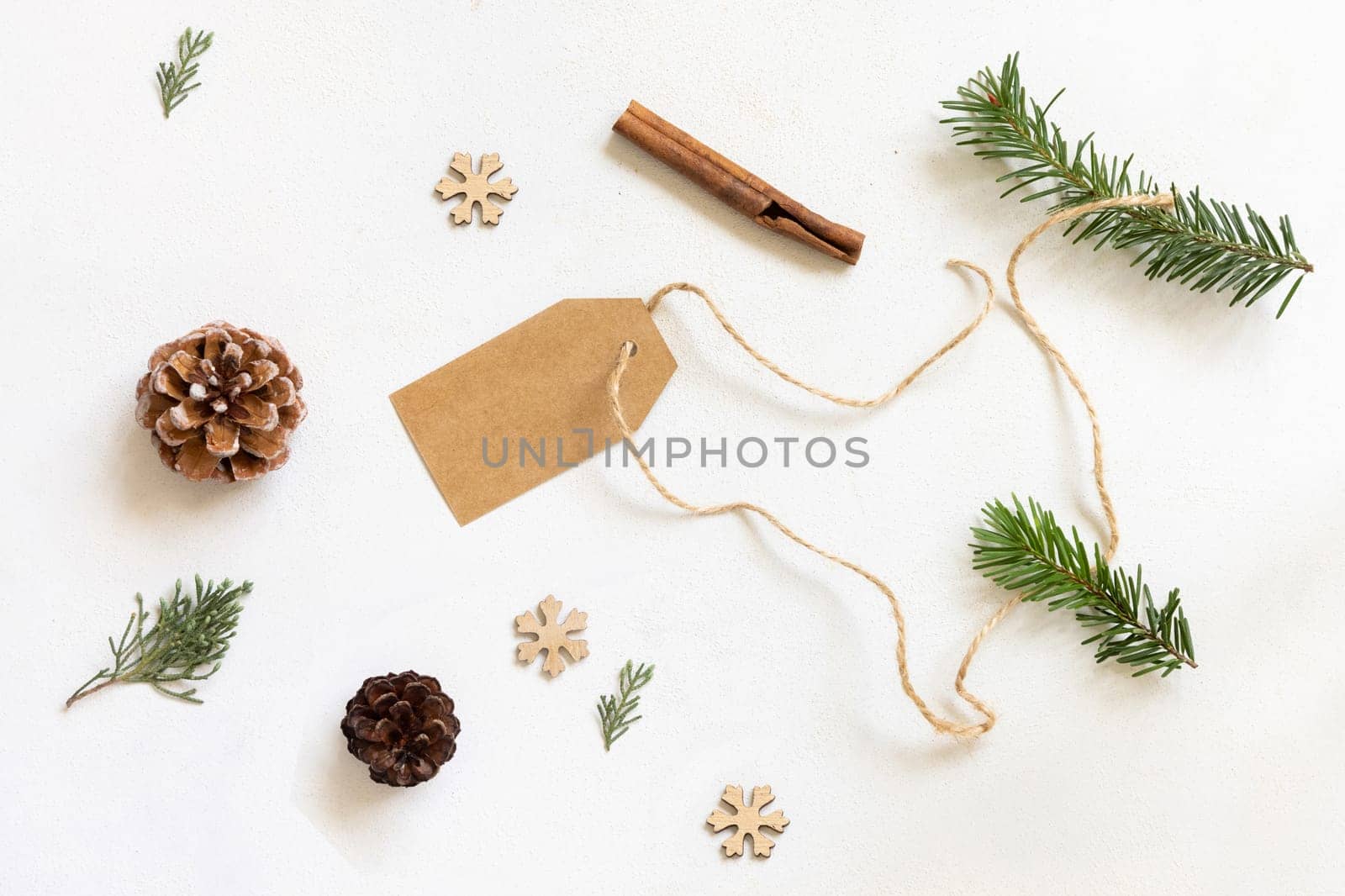 Blank gift tag, Christmas decor and green fir branches top view, copy space, mockup. Christmas or New Year Holiday atmospheric flat lay